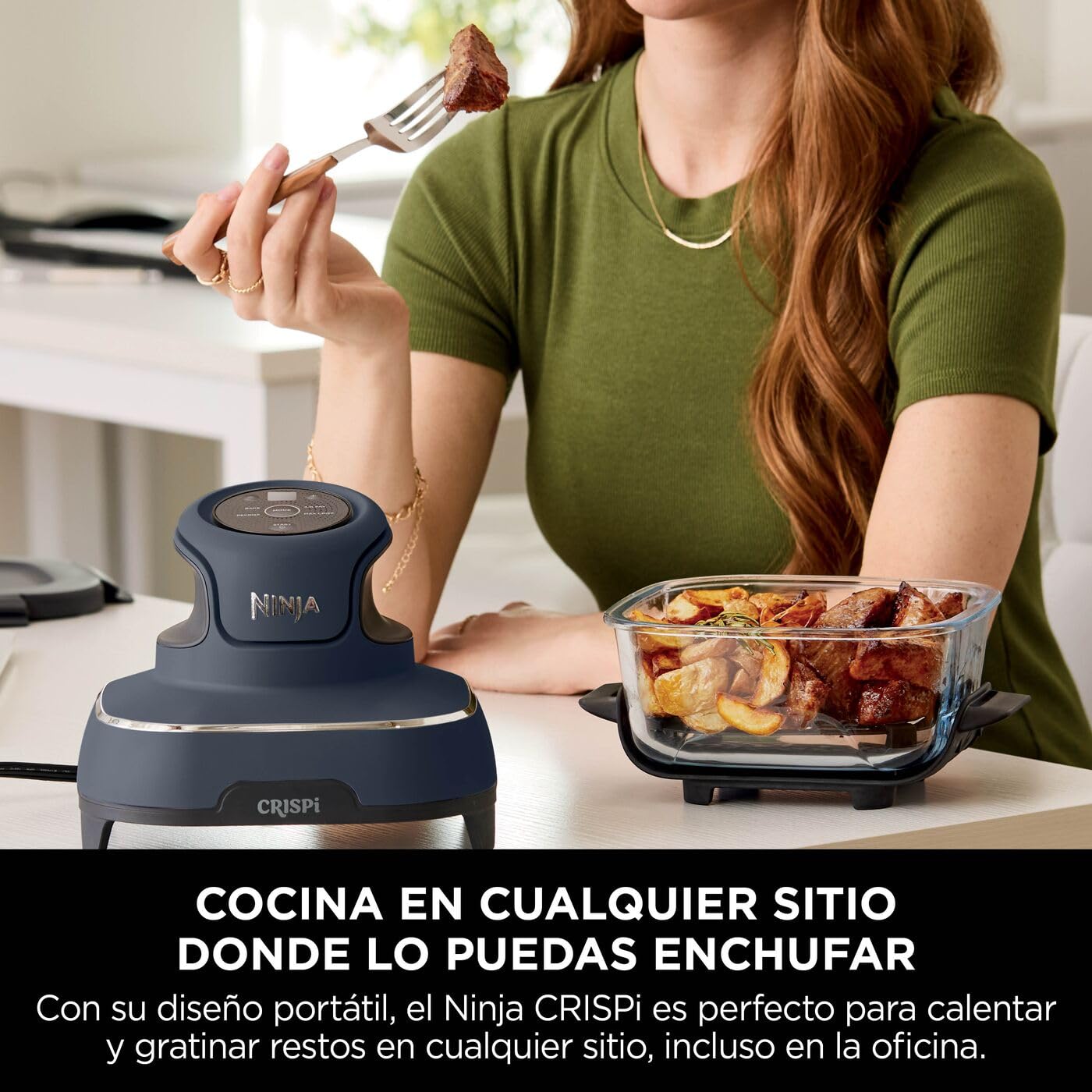 Mujer comiendo carne asada cocinada con la freidora de aire portátil Ninja CRISPi azul marino y su recipiente de vidrio