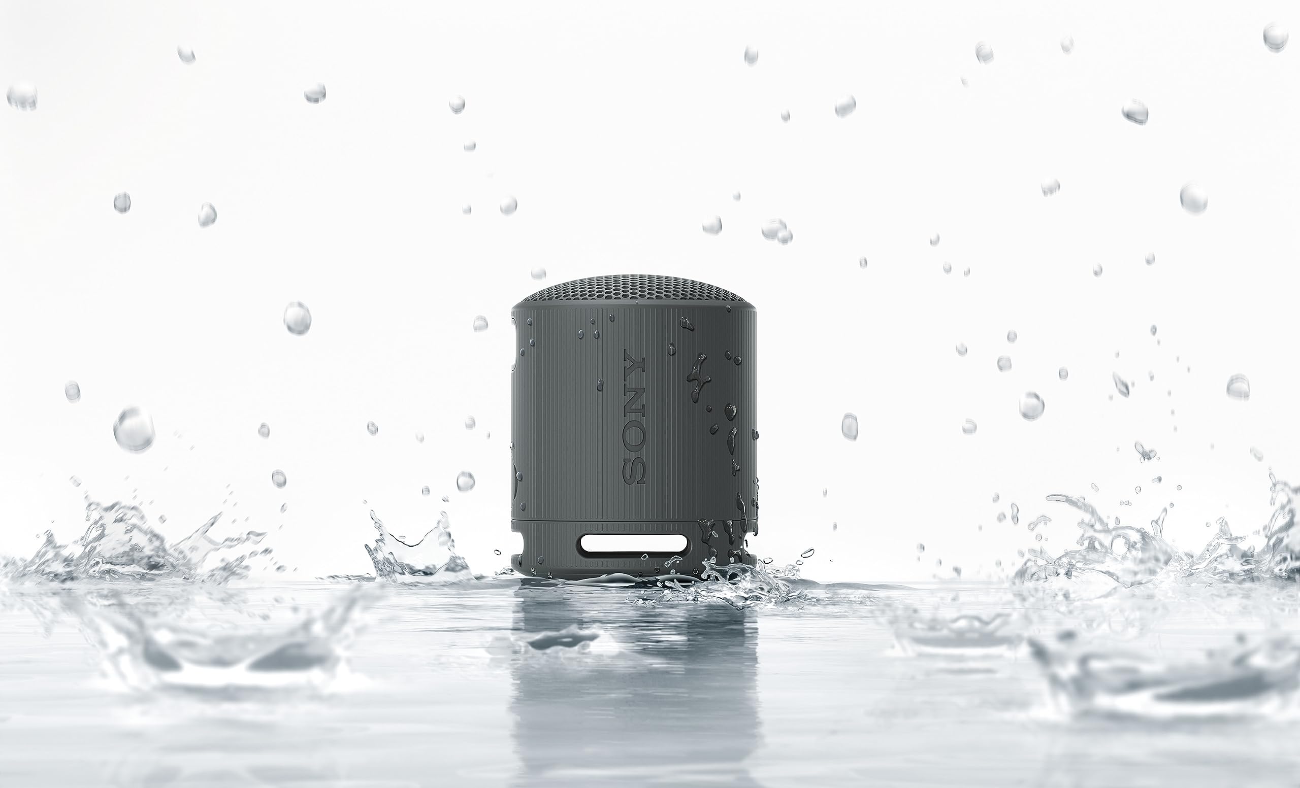 Altavoz Bluetooth Sony SRS-XB100 negro resistente al agua con salpicaduras, mostrando protección IP67.