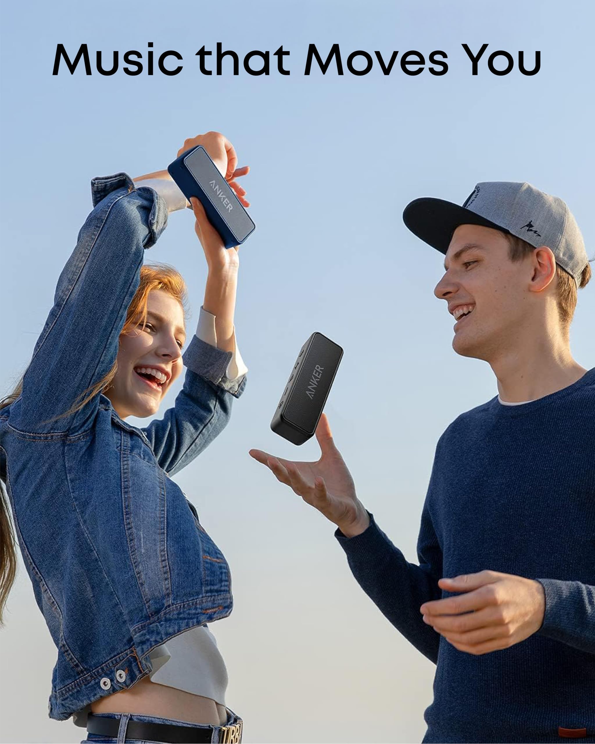 Pareja jugando con altavoz Bluetooth Anker Soundcore 2 azul y negro al aire libre