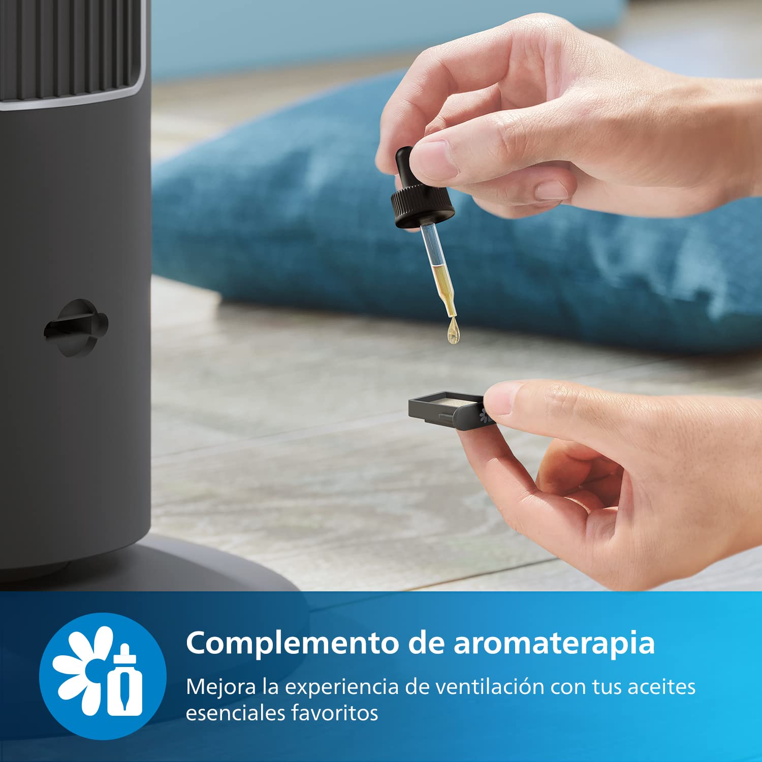 Manos aplicando aceite esencial al complemento de aromaterapia del ventilador de torre Philips Serie 5000 negro