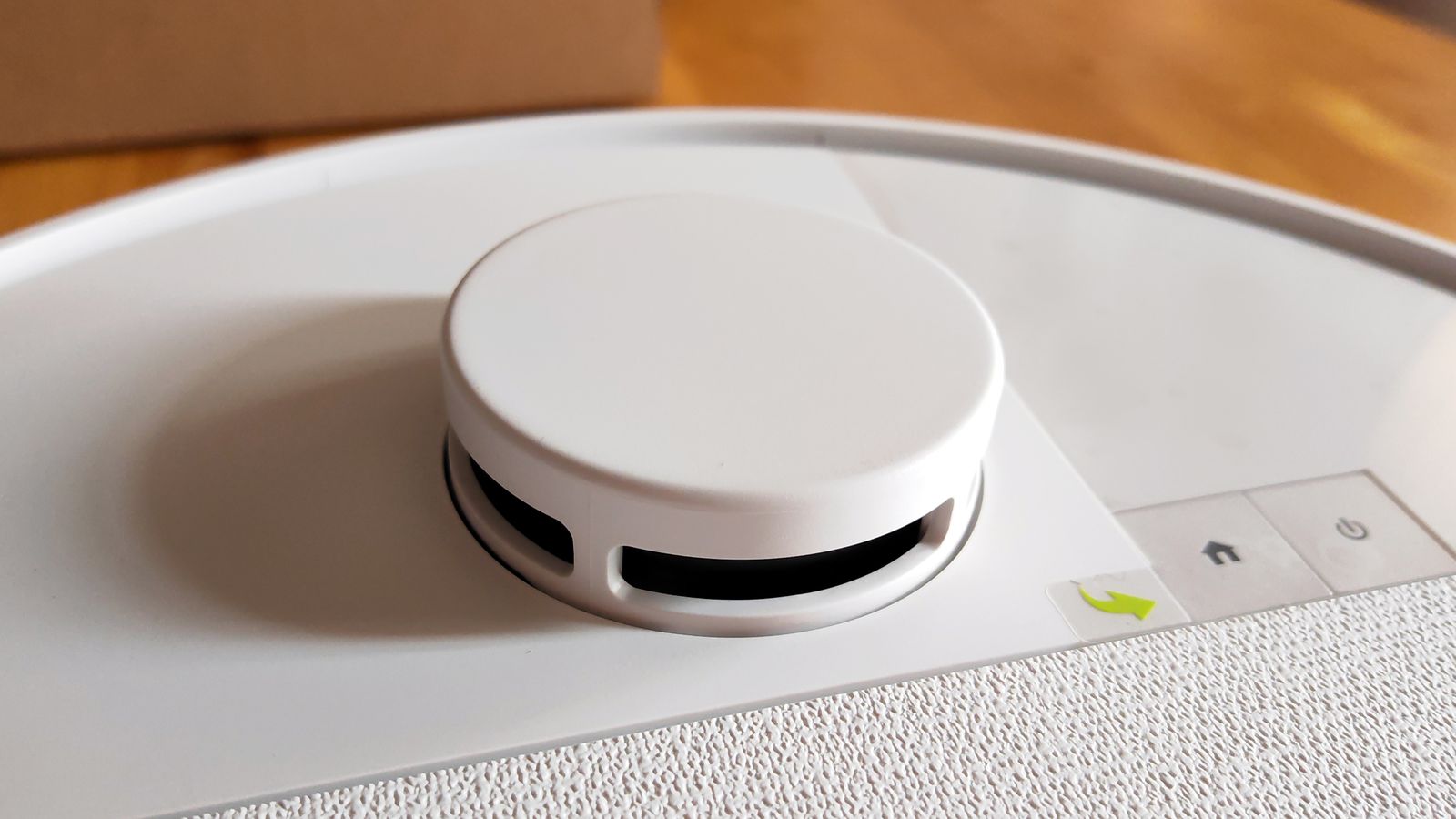 Sensor y controles de robot aspirador blanco