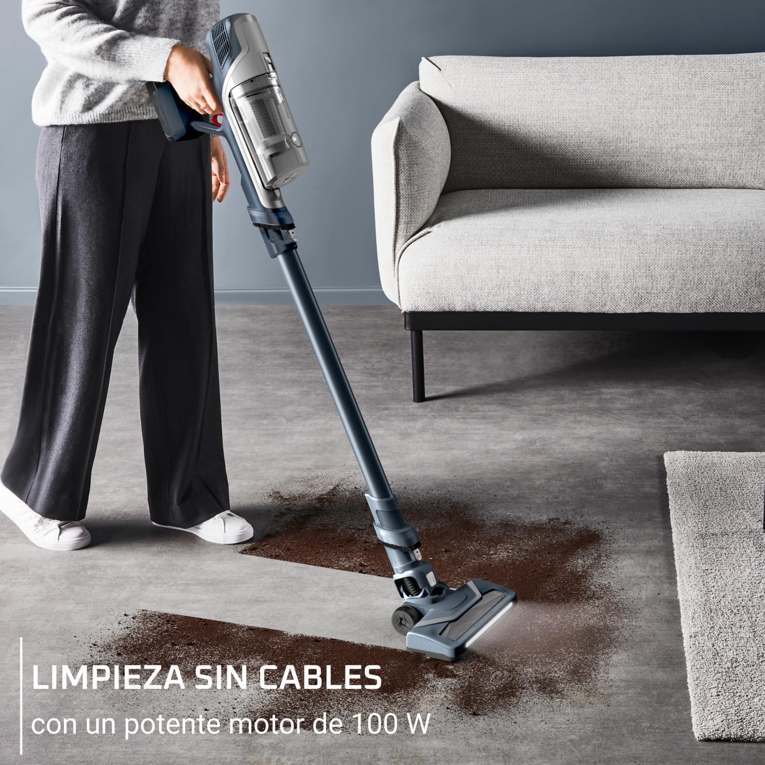 Persona utilizando la Rowenta X-Pert 6.60 para aspirar un suelo junto al sofá