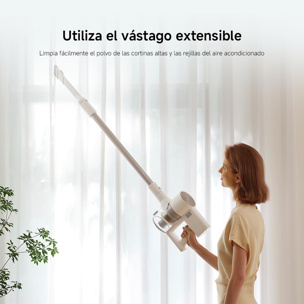 Mujer usando aspiradora XIAOMI G20 con vástago extensible para limpiar cortinas.