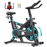 Bicicleta estática de spinning negra con detalles turquesa, volante de inercia y accesorios incluidos como portabotellas y soporte para móvil