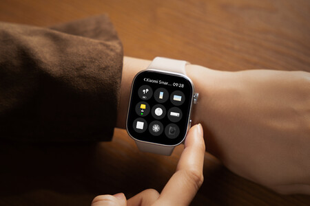 Smartwatch Xiaomi con correa blanca en muñeca mostrando menú de aplicaciones y hora.