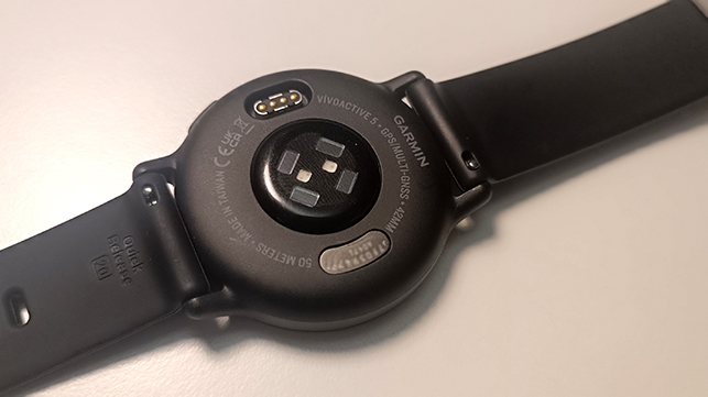 Parte trasera de smartwatch Garmin Vivosactive 5 con sensor cardíaco y puerto de carga.