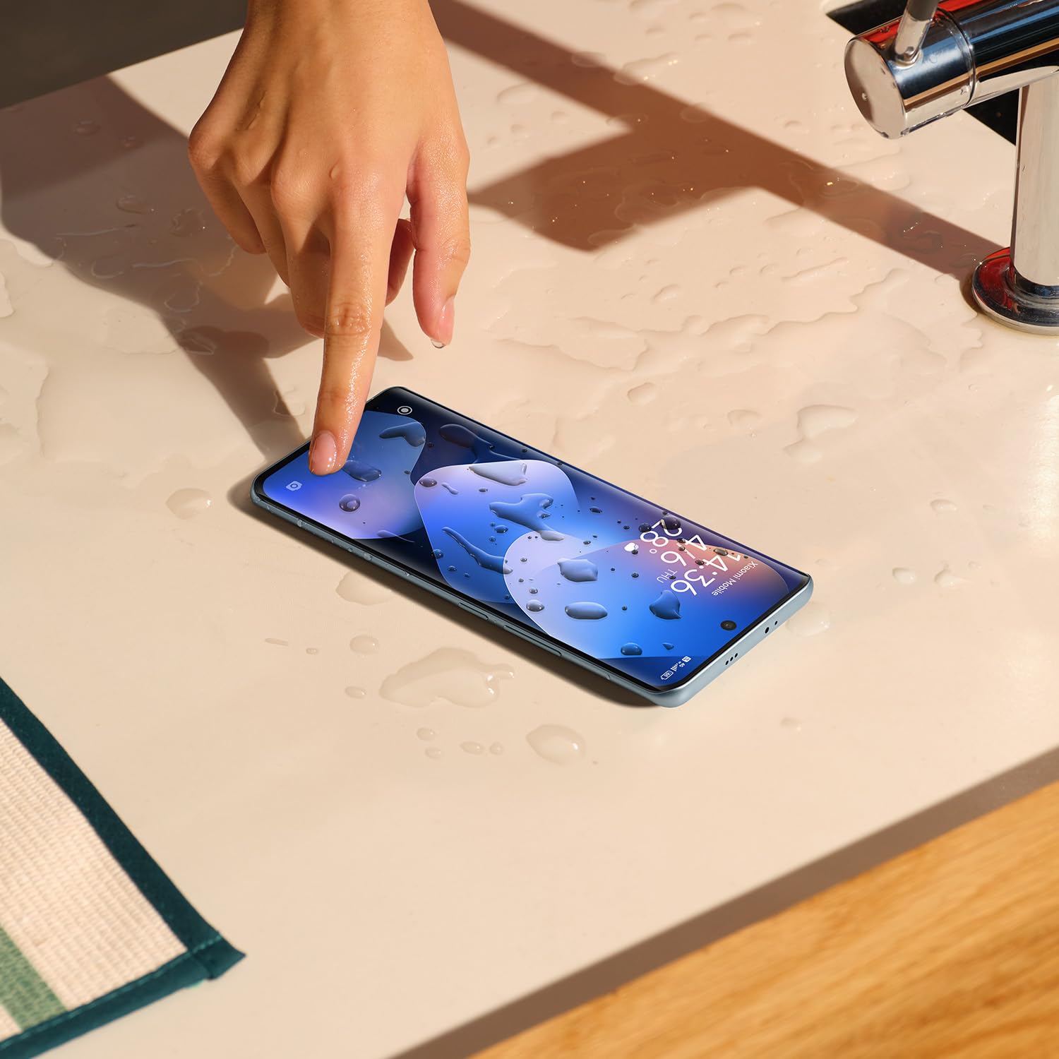 Xiaomi Redmi Note 15 con pantalla mojada demostrando resistencia IP64 en encimera de baño