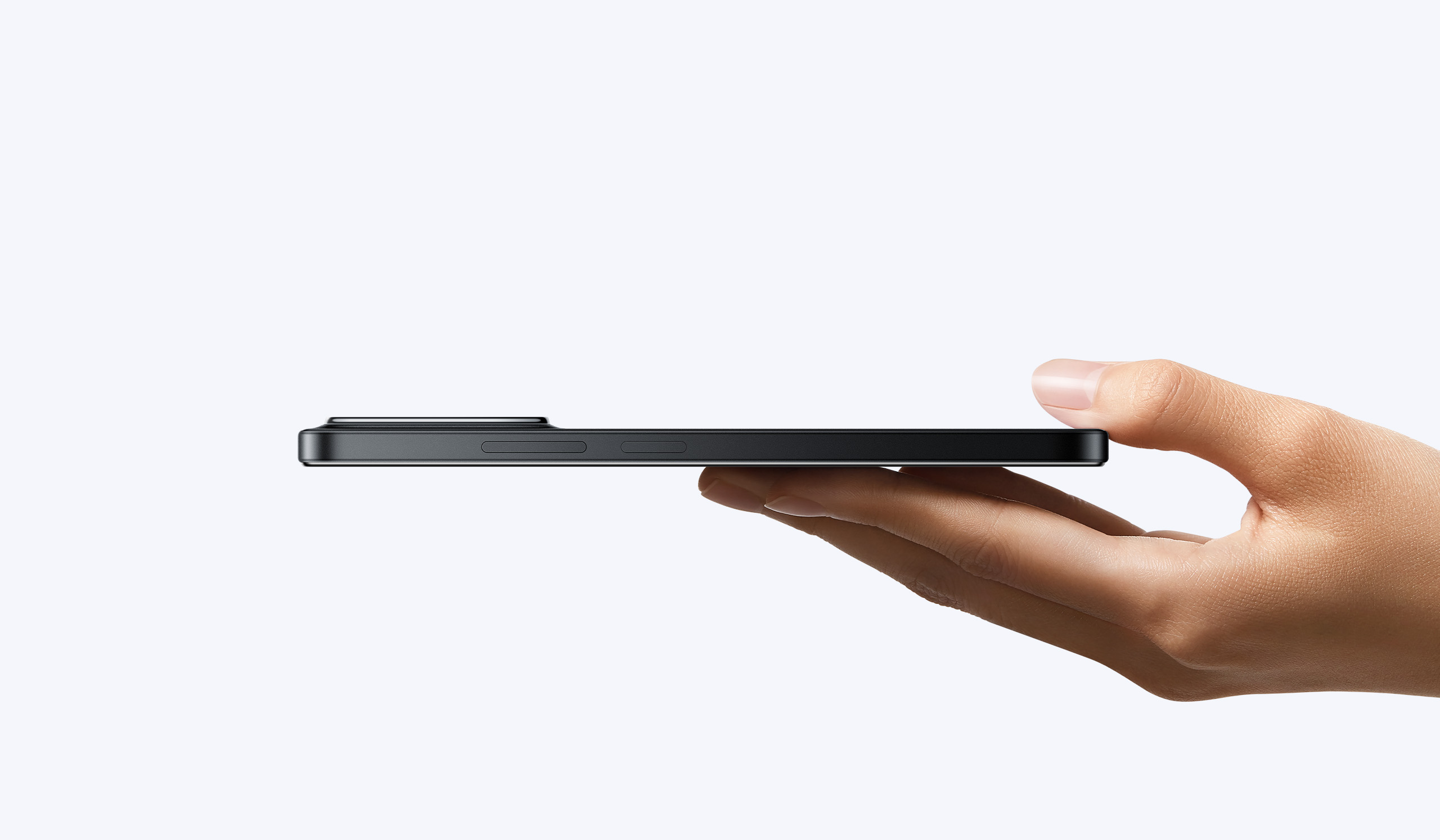 Vista lateral de smartphone negro sostenida por una mano mostrando su diseño delgado y botones laterales