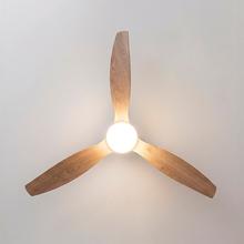 Ventilador de techo de madera con tres aspas y luz central cálida, estilo moderno y minimalista.