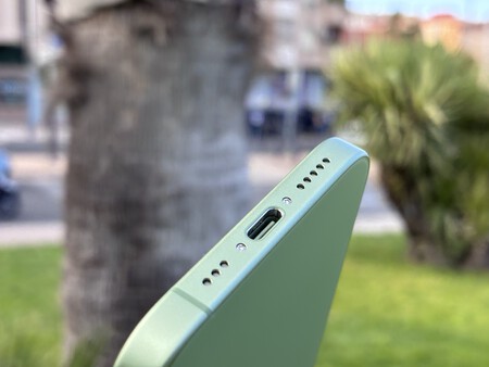 Detalle del puerto USB-C y altavoces inferiores de un smartphone verde menta