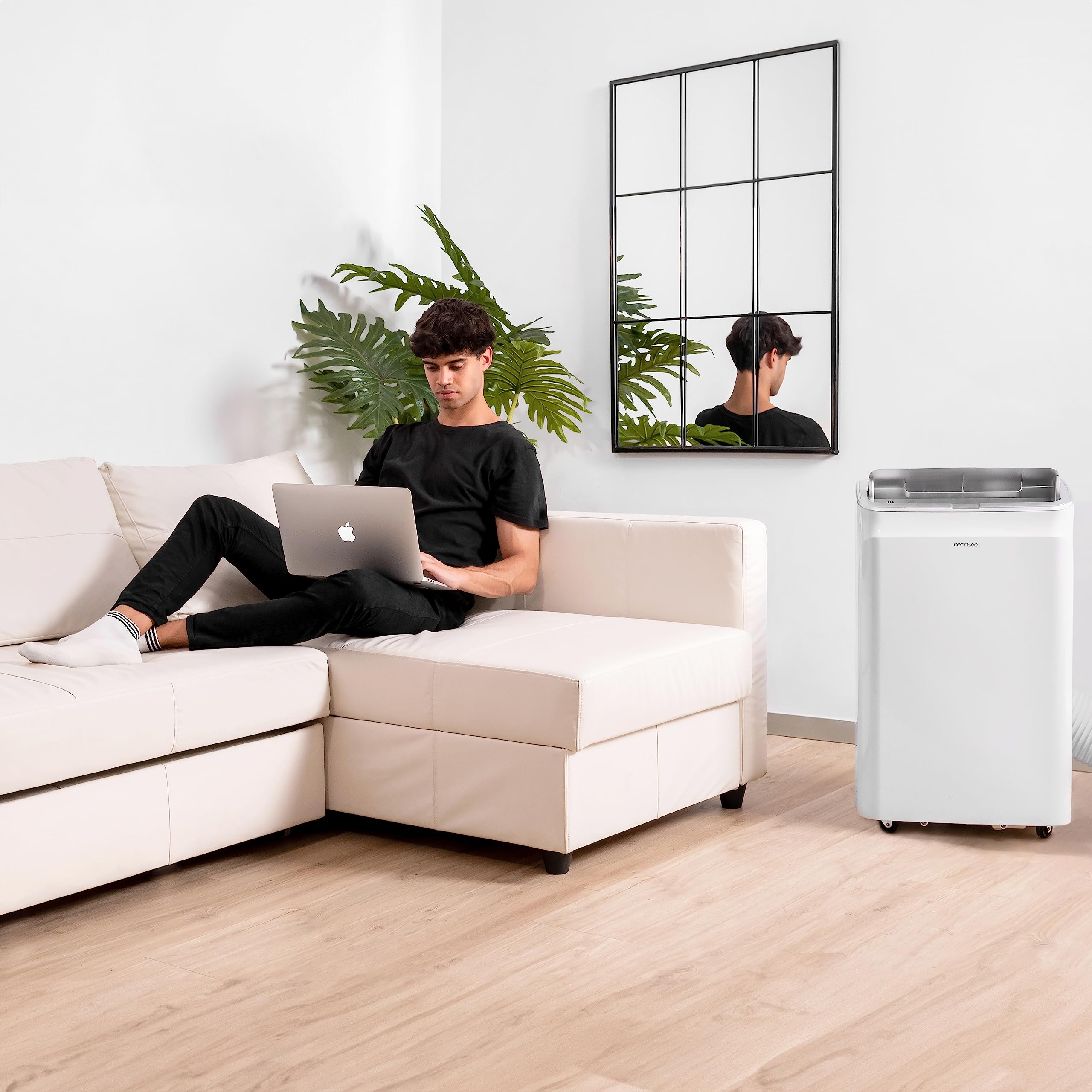 Aire acondicionado portátil Cecotec en sala moderna con hombre usando portátil.