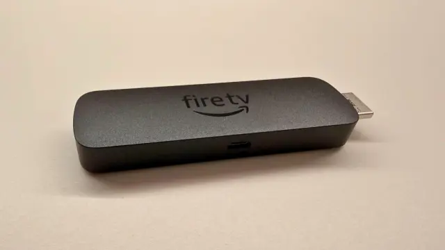 Dispositivo Fire TV de Amazon en plano detalle sobre fondo beige