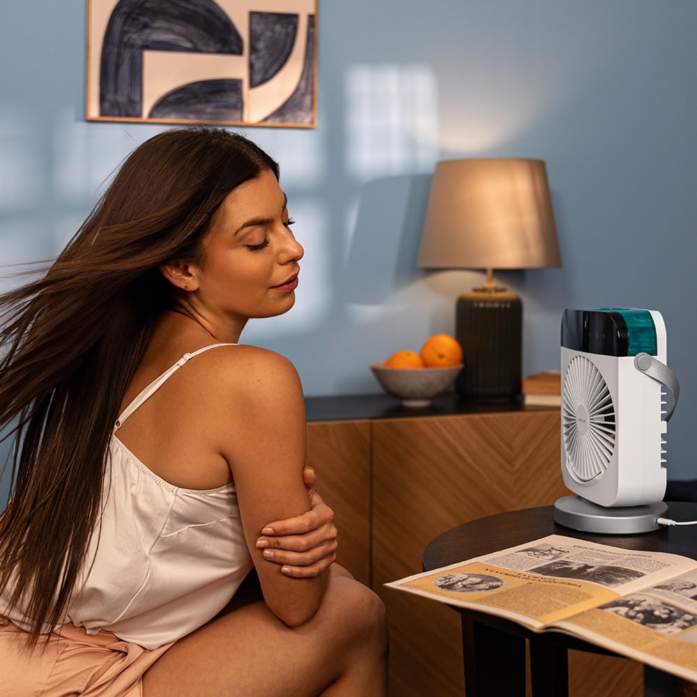 Mujer recibiendo el aire del climatizador Cecotec DeskChill sobre una mesa