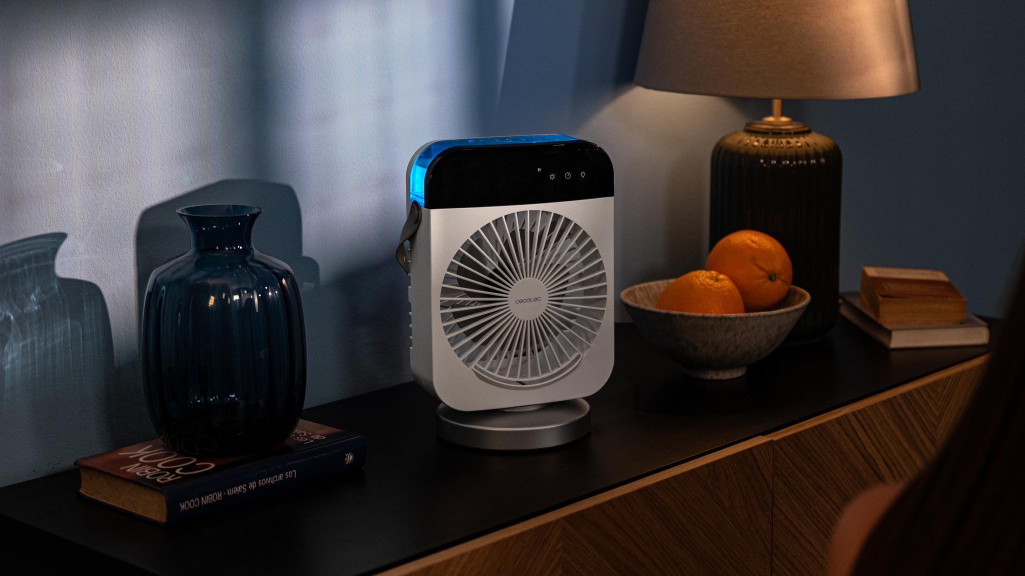 Ventilador portátil moderno en una habitación oscura, con luz de fondo