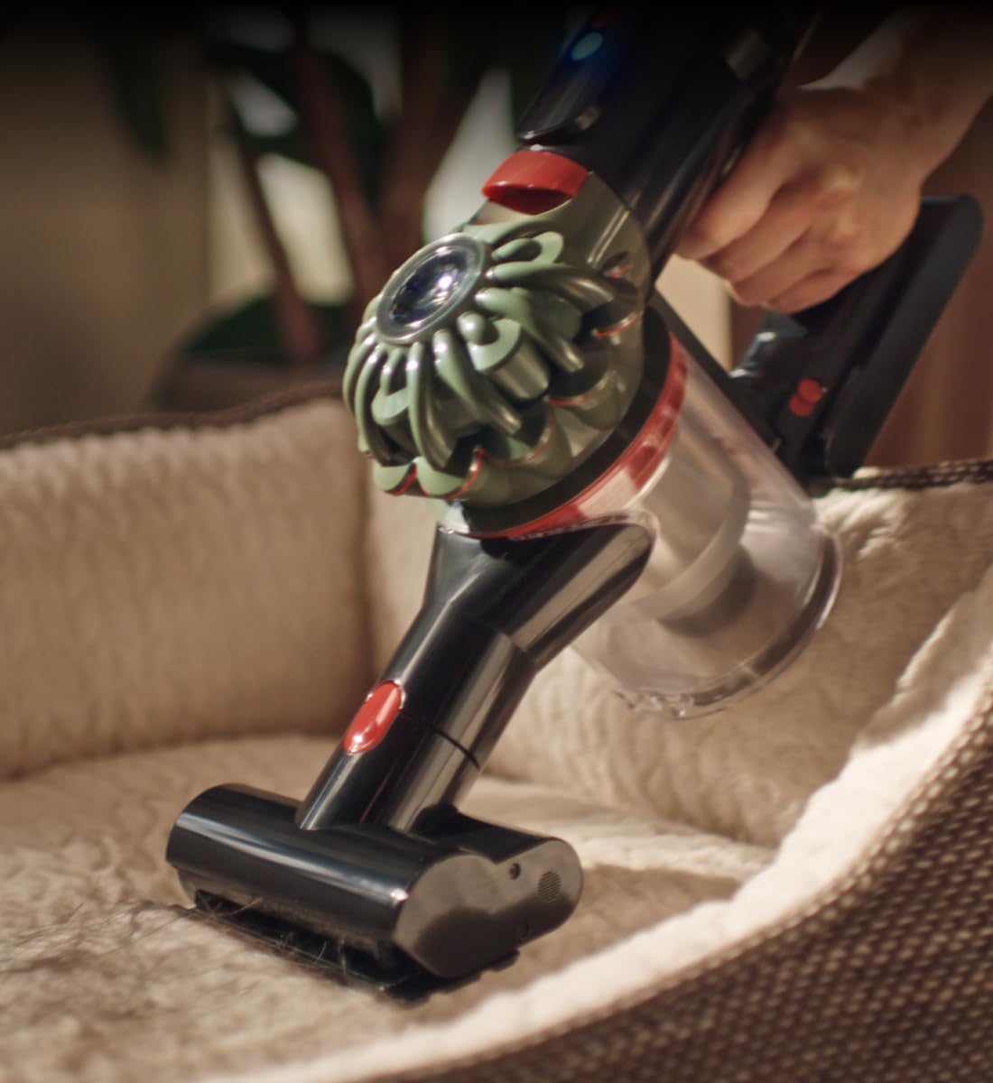 Aspiradora Dyson V8 Cyclone en uso sobre una cama.