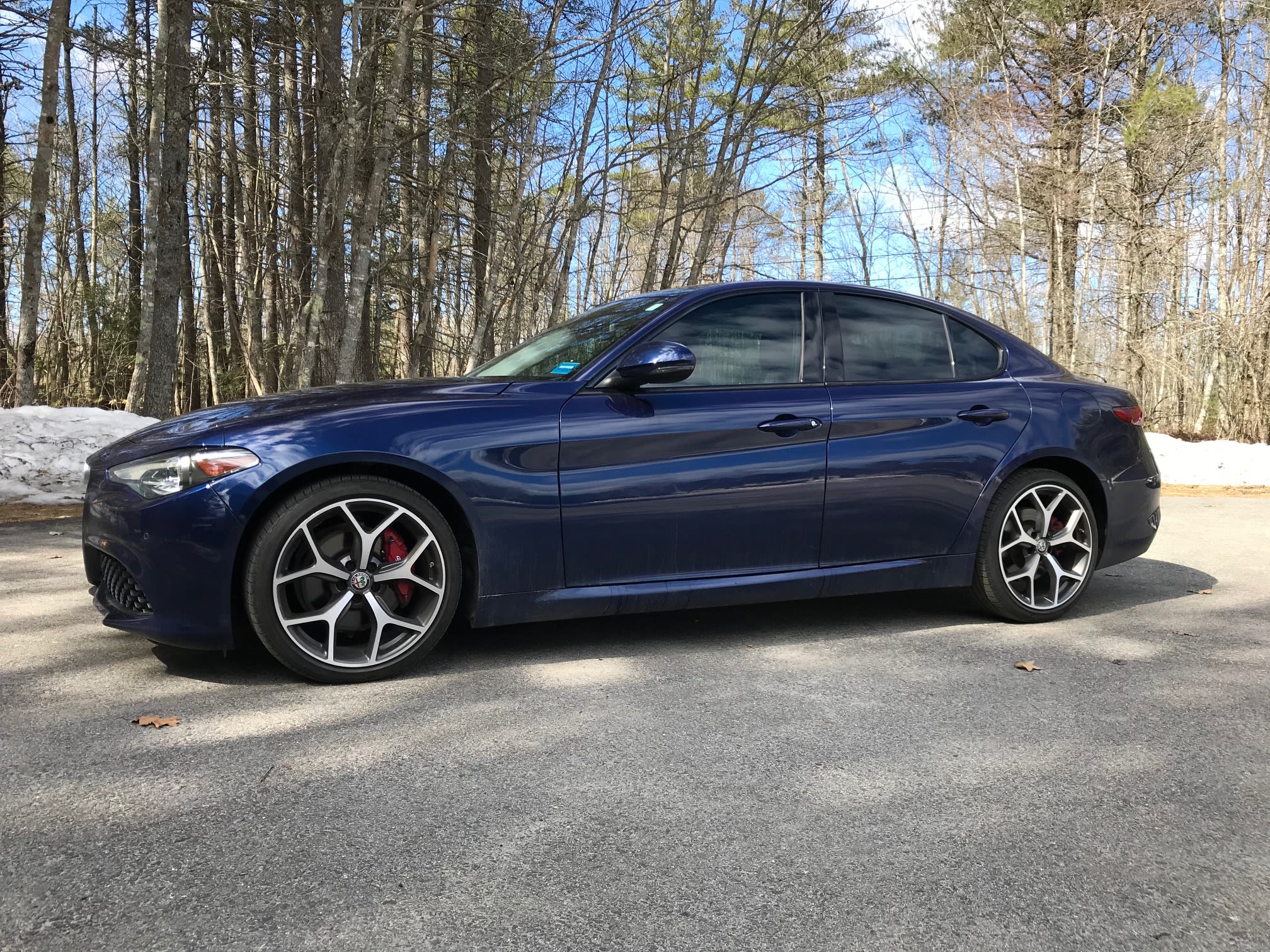 Blue Alfa Romeo Giulia sedan with tinted windows in driveway