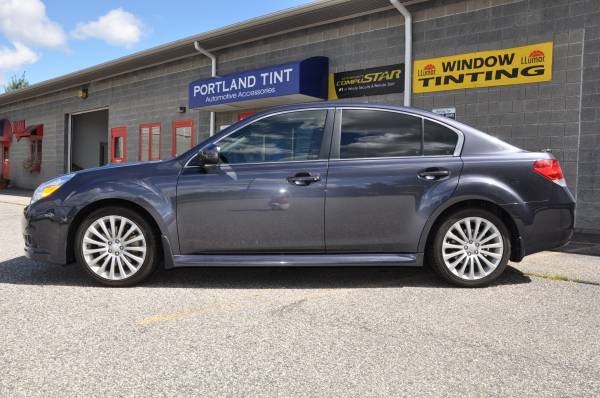 Gray Subaru Legacy sedan with tinted windows at shop