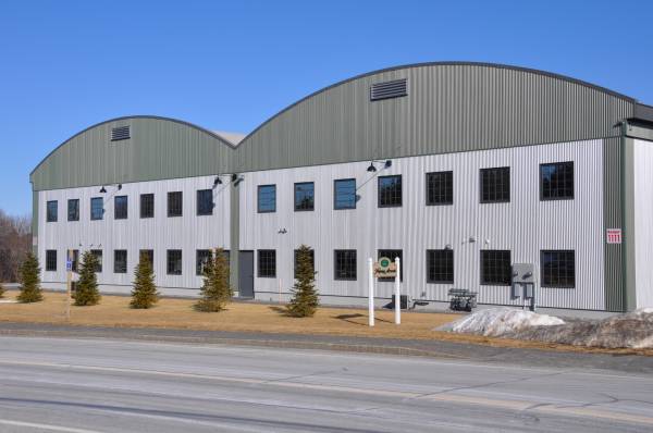 Two-story metal commercial building with rows of office windows