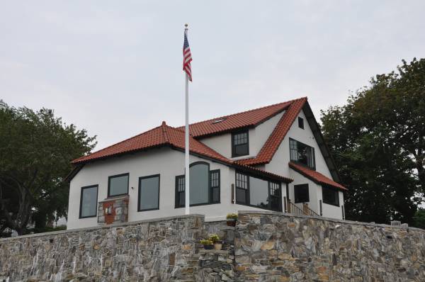 Coastal home exterior with tinted windows on stone wall