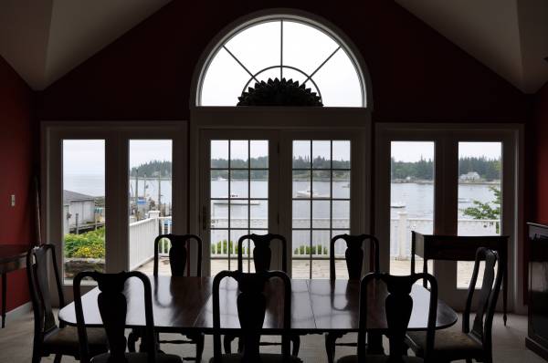 Dining room with arched windows and water-view tinted glass doors