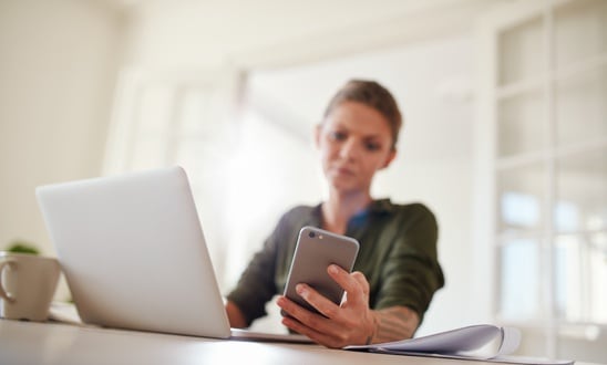 woman reading text message reminder on mobile phone