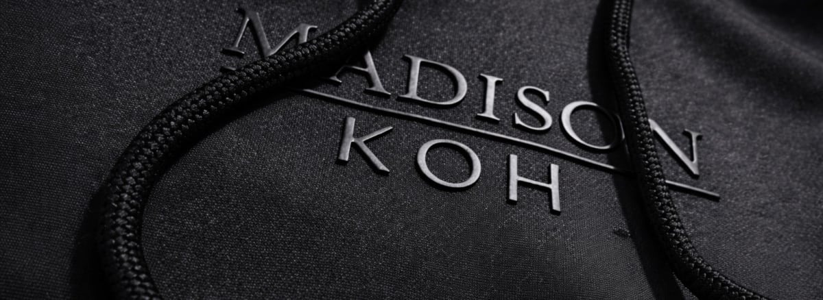 Debossed 'Madison Koh' private label branding on a black hoodie