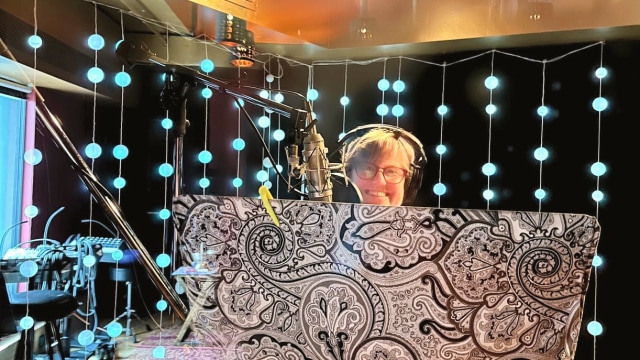 Alicia Mathewson — Person displaying ornate patterned fabric in studio