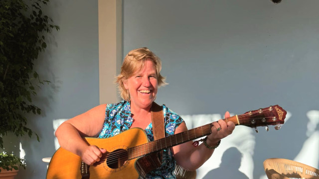 Alicia Mathewson — Woman performing acoustic guitar outdoors