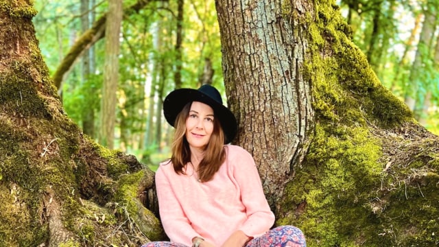 Alison Potts — Woman seated between moss-covered trees