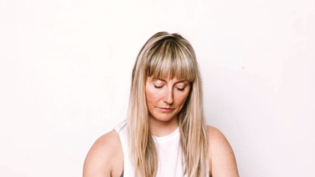 Carolyn Anne Budgell — Woman meditating on wooden floor
