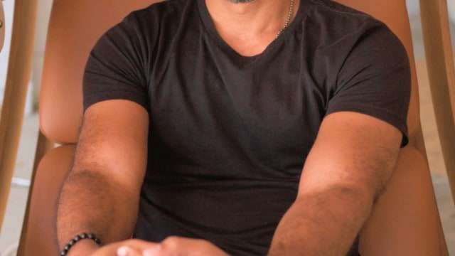 Chibs Okereke — Man smiling in tan chair