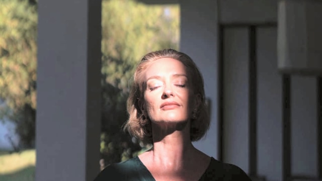 Ricci-Jane Adams — Woman in dark wrap top, dramatic architectural lighting