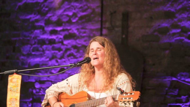 Sacred Earth — Woman performing with acoustic guitar onstage