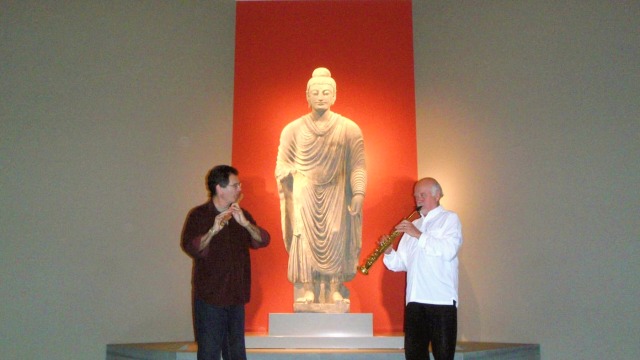Steve Gorn — Musicians flanking illuminated Buddha statue