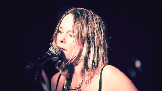 Vanessa Forbes — Female performer singing at microphone