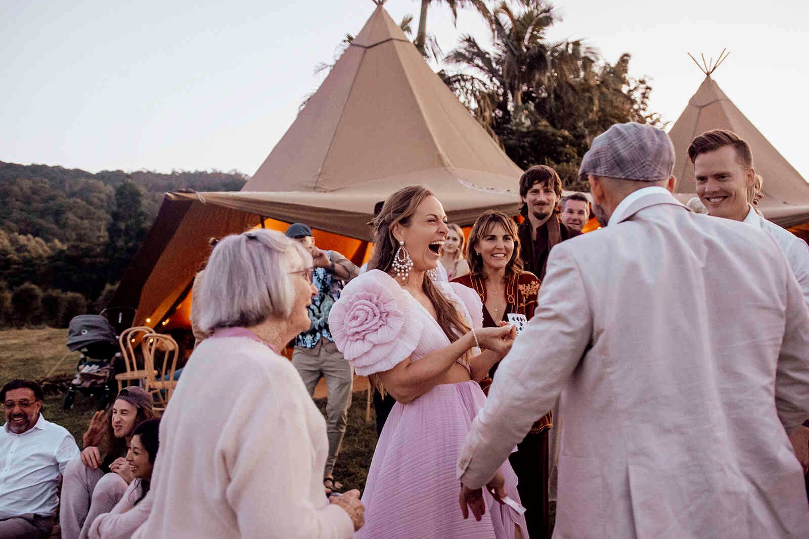 bride_laughing_guests_reception_teepee_tent_evening_bcdec33782