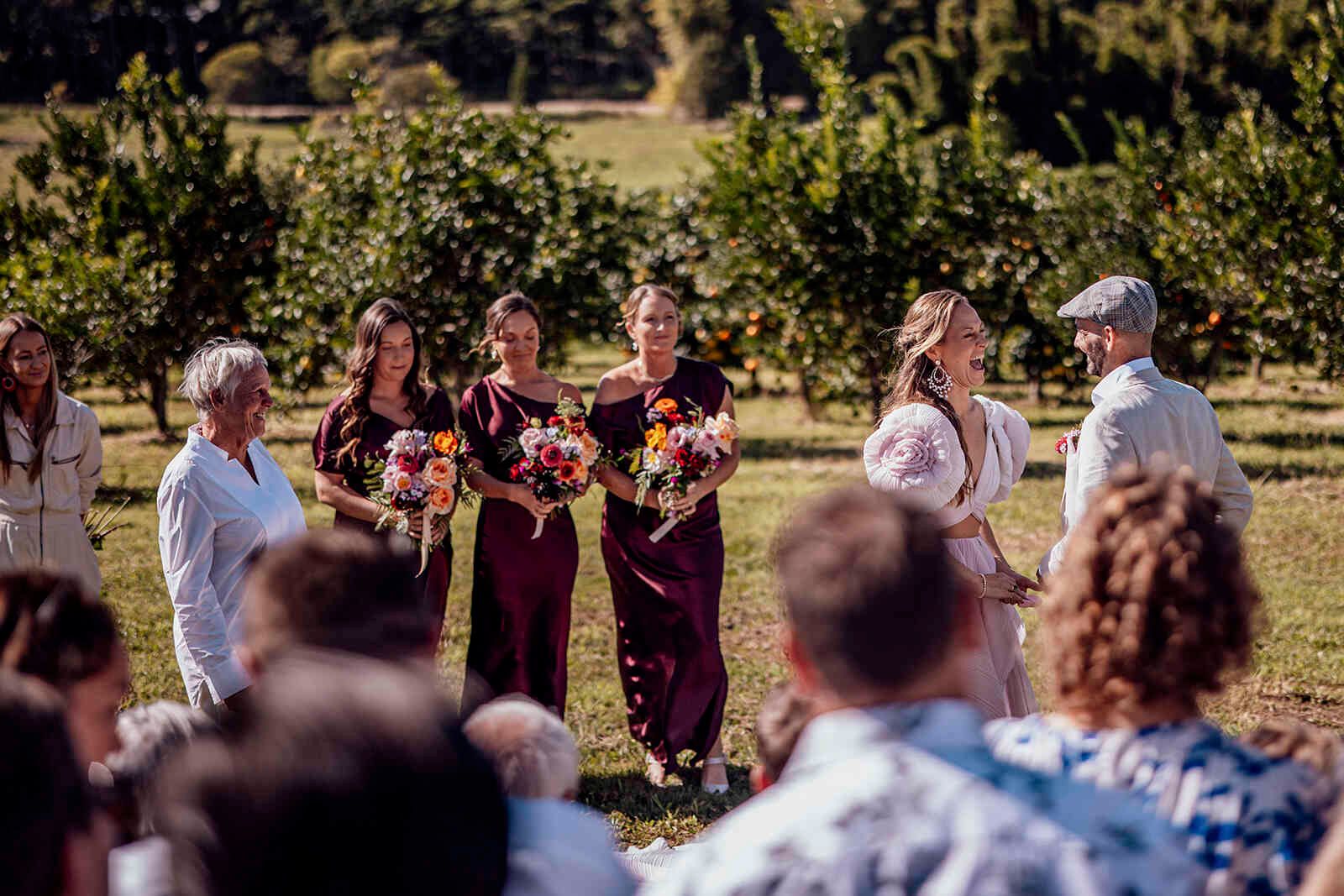 bride_groom_vows_outdoor_ceremony_bridesmaids_burgundy_c8bdf17629