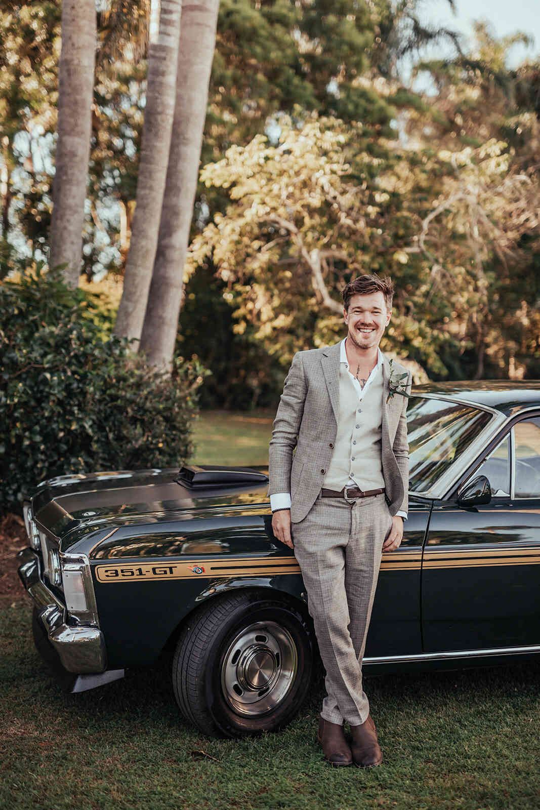 sarah_and_jeff_groom_jeff_posing_with_classic_mustang_car_cb05f92eb5