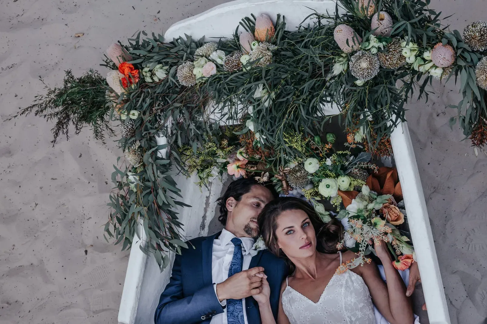 beach_byron_bay_wedding_overhead_shot_couple_in_floral_boat_43aa196b65