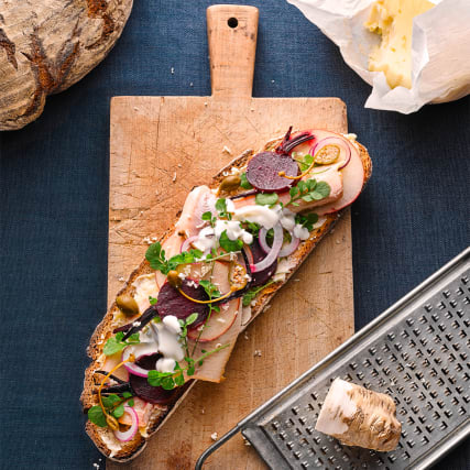 Sauerteigbrot mit Rauchforelle, Randenpickles, Apfel, roten Zwiebeln, Kresse, Kapernäpfeln, Sauerrahm und Meerrettich.