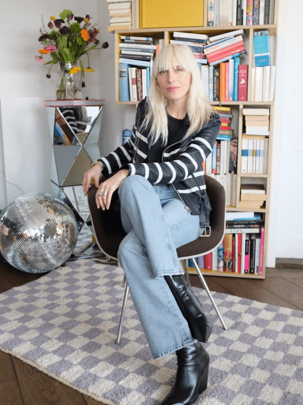 Cloudy Zakrocki in Citizens of Humanity auf Teppich von Hand in Hand zuhause in Berlin