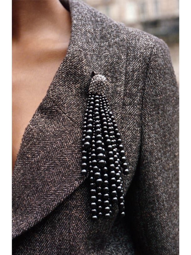 Schwarze Brosche aus Perlen an braunem Mantel