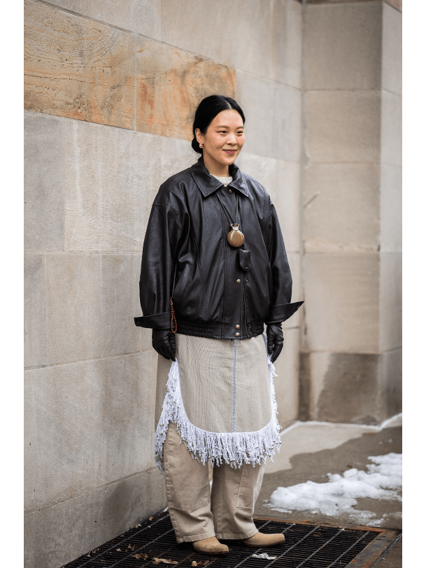 Frau in Lederjacke und Pendelkette