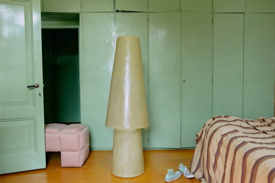 Stehlampe aus gelbem Glassfiber in grünem Wohnraum annabelle