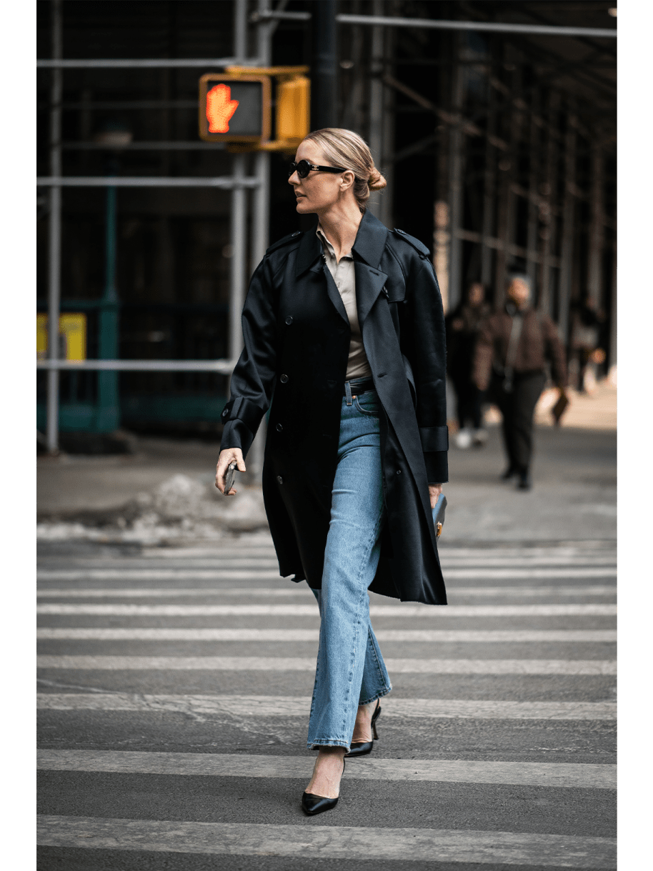 Frau in Jeans und schwarzem Mantel