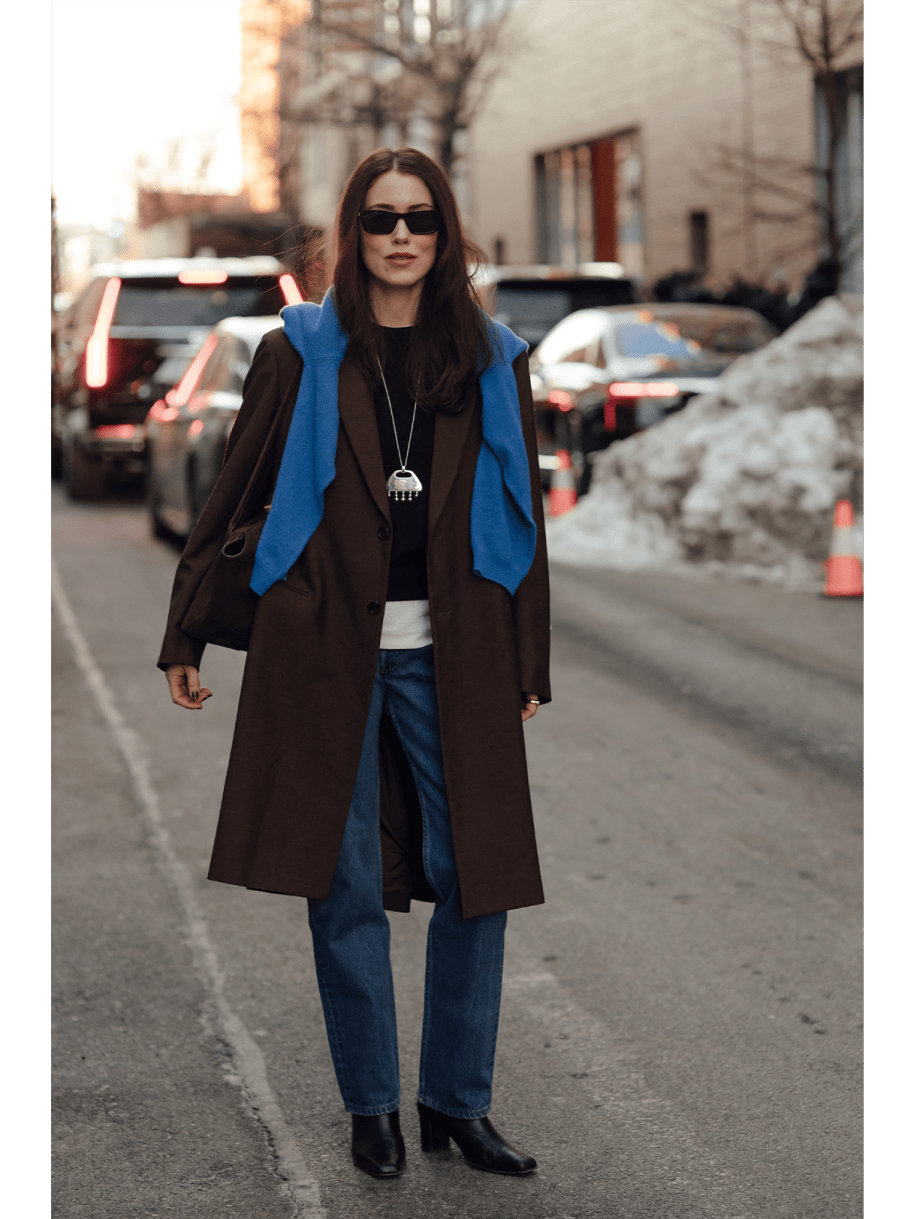Frau in Jeans, Mantel und blauer Pullover