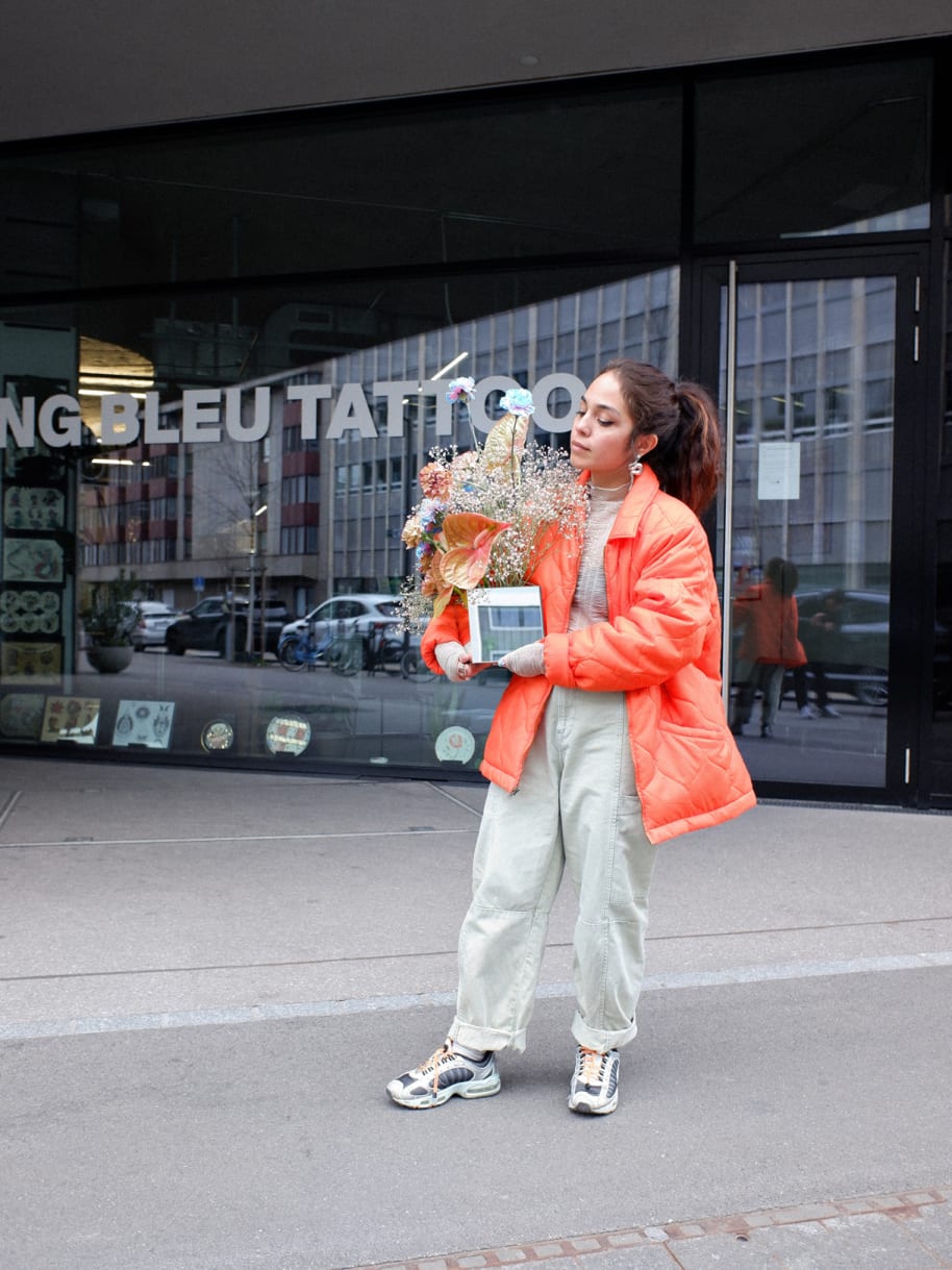 Jenni Tschugmell in Stüssy vor dem Sang Bleu Tattoo in Zürich mit ihren Blumen von Floral.TV