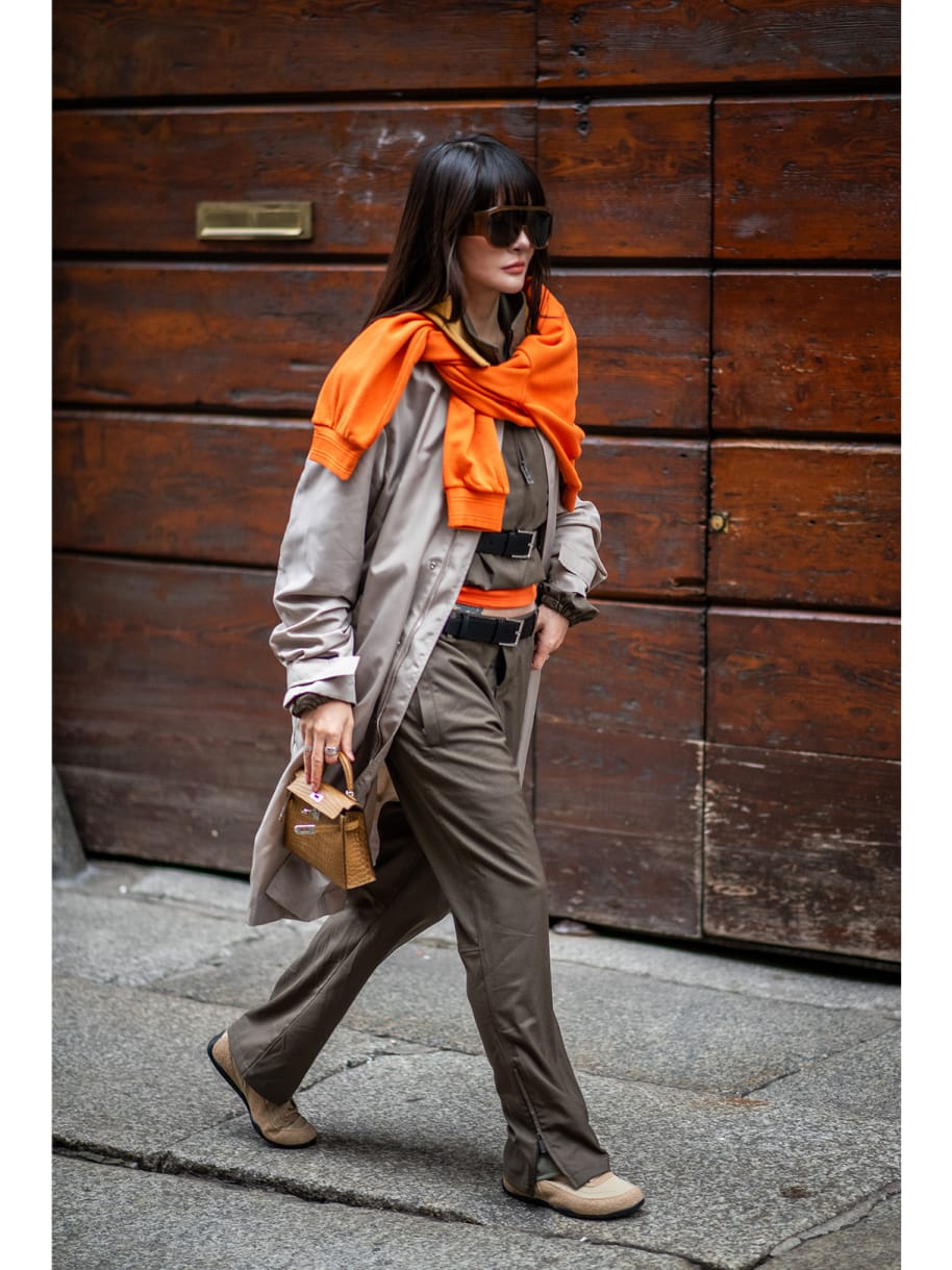 Frau mit orangenen Pullover Fashionweek