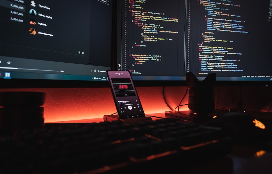 A developer coding on a laptop with software interfaces displayed