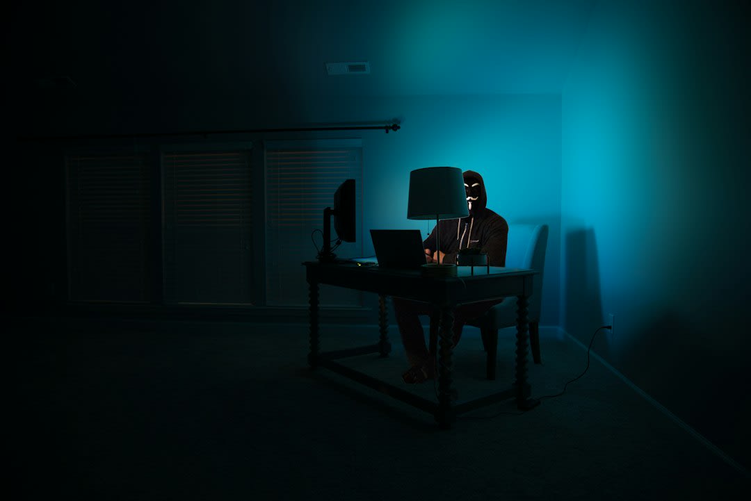 A hacker sitting in front of multiple screens displaying code and security breaches